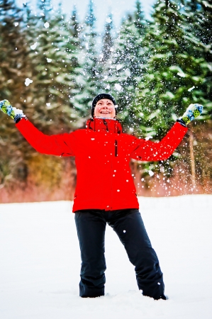 Female throwing a pile of snow up into the air. Female is in focus.の写真素材