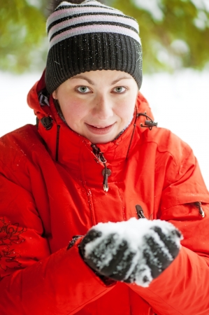 Portrait of a woman who keeps a handful of snow in her handsの写真素材
