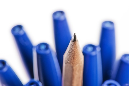 Sharpened pencil between pens in caps.の写真素材