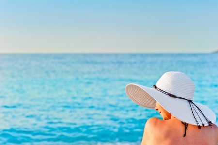 girl in white hat on the beach sunbathingの写真素材