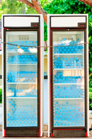two refrigerators full of water bottles under lock and keyの写真素材