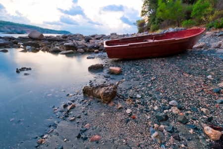 boat on the rocky shore in the early morningの写真素材