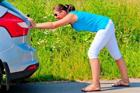 woman pushing car out of gasolineの写真素材