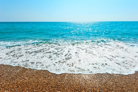 foamy wave rolls on a sandy beachの写真素材