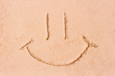 smiley face on the wet sandの写真素材