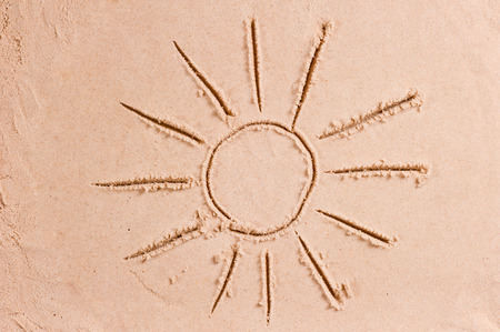 beautiful drawing of the sun with rays on the sandの写真素材