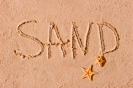 word written on the beach sand and starfishの写真素材