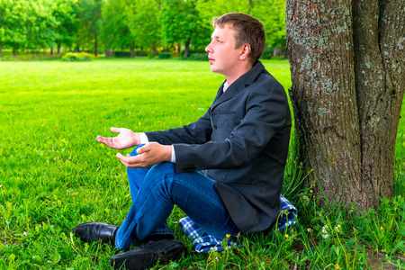 Businessman relaxing in the park near the treeの写真素材