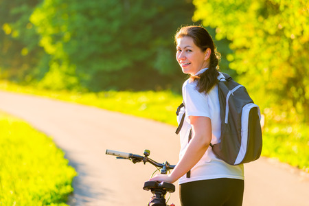 Brunette rides a bicycle on a sunny morningの写真素材