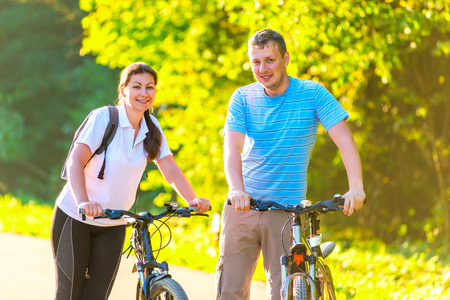 young couple on the weekend to ride a bike in the parkの写真素材
