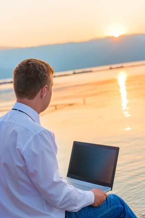 successful businessman on the beach with a laptopの写真素材