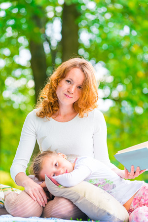 Vertical portrait of a mother and daughter in the parkの写真素材