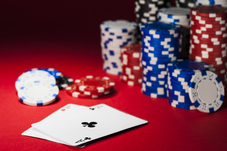 cards and poker chips on a red cloth