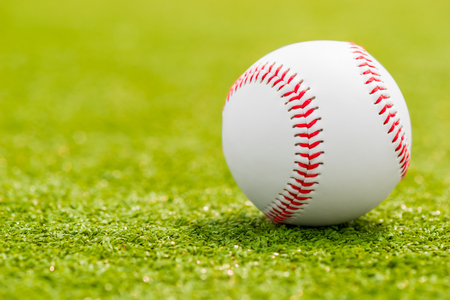ball for playing baseball is on the green grass macro shotの写真素材