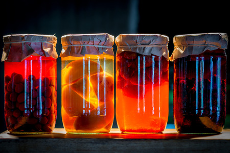Four cans of compote fruit and berries illuminatedの写真素材