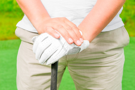 male hand in a glove with golf club close-upの写真素材