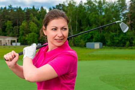 focused girl is preparing for the game of golfの写真素材