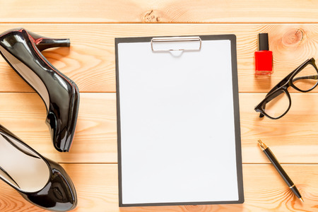 Black patent leather shoes and paper blank a close-up on the wooden floorの写真素材