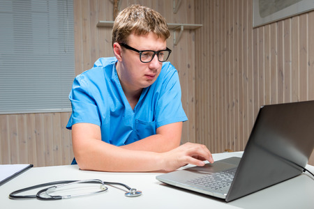 serious male Doctor with glasses working on computerの写真素材