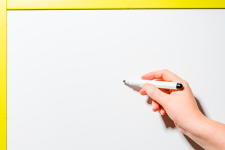 woman's hand holding a black marker to the board space for an inscriptionの写真素材