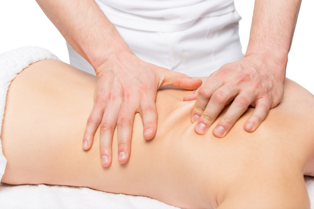 male masseur does back massage on a massage tableの写真素材