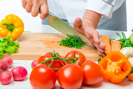 fresh raw vegetables for salad and chef hands with a knife close upの写真素材