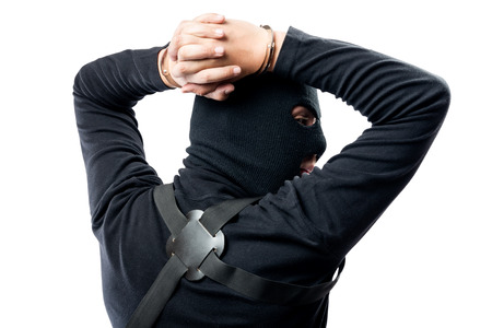 Hands in handcuffs behind the head of the criminal close-up, the criminal in the maskの写真素材