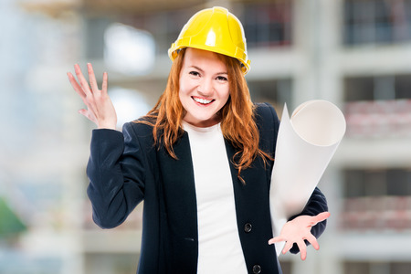 Women chief architect with drawings in a yellow construction siteの写真素材