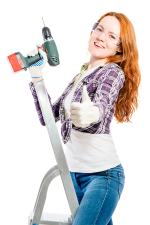 happy young woman with a tool on a white backgroundの写真素材