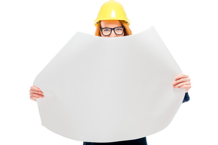 architect with blueprints on a white background in studio in a yellow hard hatの写真素材