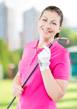 happy golfer on a background of golf courses smiling and holding a golf clubの写真素材