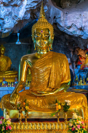 god Buddha in gold clothes gold sculpture in the cave of the tiger in Thailand, Krabiのeditorial素材