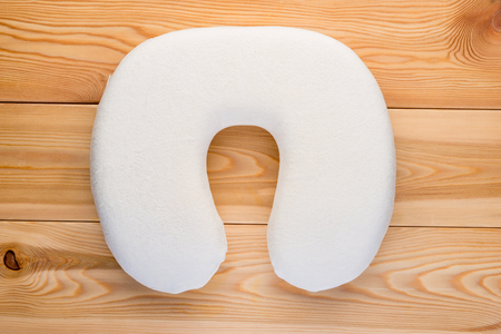 soft comfortable pillow for traveling by plane or car on a wooden table top viewの写真素材