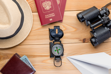 passport, money and navigation equipment for traveling on a given course close-up on wooden boardsの写真素材
