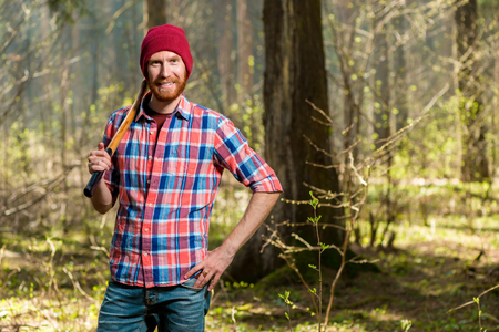 horizontal portrait of a forester with a beard in the forest with an axの写真素材