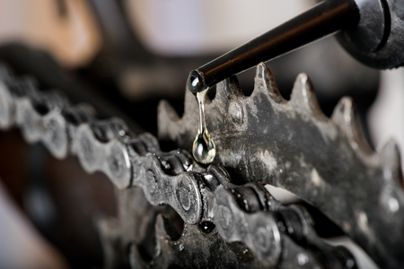 a drop of oil and a mountain bike chain close upの写真素材