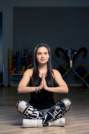 beautiful brunette doing yoga in the gym, simple asanasの写真素材