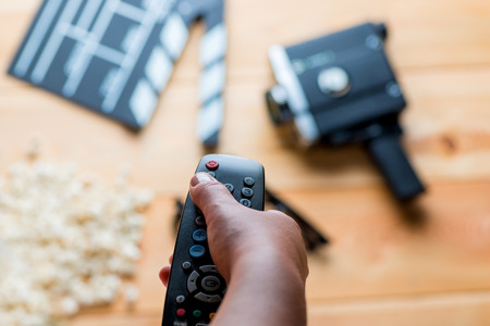 remote from the TV in hand on the background of movie objectsの写真素材