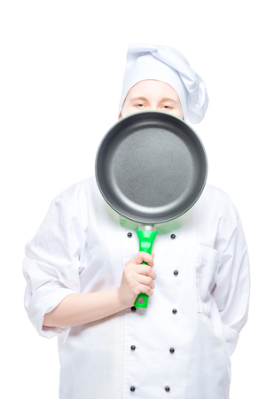 cook peeking from behind the frying pan, studio shot on whiteの写真素材