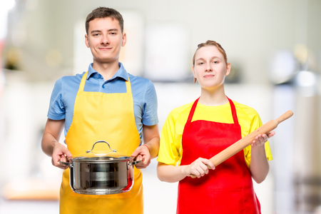 a man with a pan and a woman with a rolling pin portrait in the kitchenの写真素材