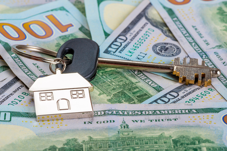 new house key on pile of american dollars close upの写真素材