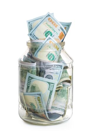 concept photo savings - a glass jar filled with 100 dollar bills isolatedの写真素材