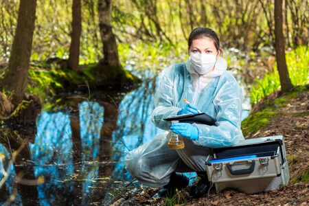biologist takes water from a forest river to study the composition in the laboratoryの写真素材