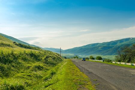 Landscape of Armenia - a car on the road in the mountains on a sunny dayの写真素材