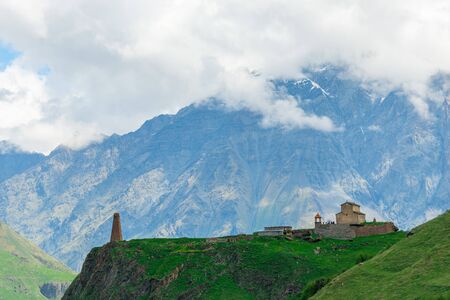Georgian buildings on the background of high beautiful Caucasian mountainsの写真素材