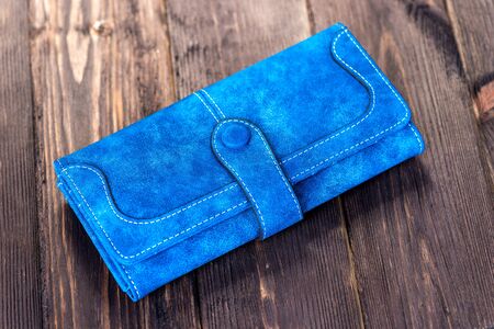 blue leather women wallet on wooden floor close-upの写真素材