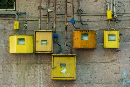 yellow electricity meters on the wall of a residential building close-up の写真素材