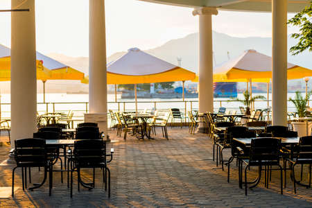 empty summer street cafe near the sea at sunsetのeditorial素材
