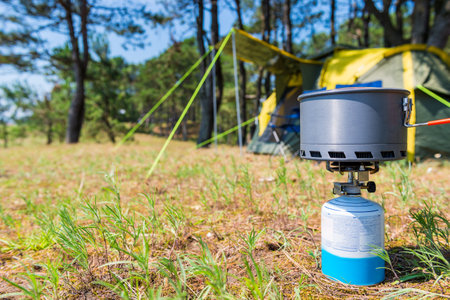 a pan for cooking in a campaign on a gas burner on the background closeup camping tentsの写真素材