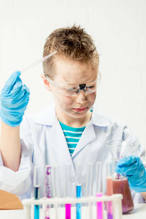 Funny boy dressed as chemist with dirty face after a failed experiment